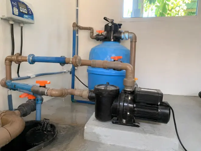 Casa de máquinas de piscina com pequeno vazamento na tubulação durante inspeção em Capão da Canoa RS.